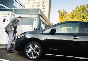 Man charging his electric vehicle at a charging point