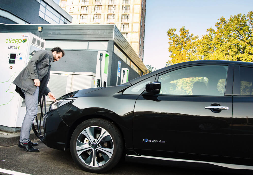 Man charging his electric vehicle at a charging point